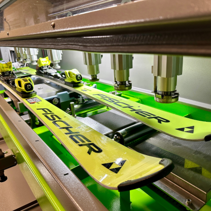 A pair of Fischer race skis going into the Wintersteiger Scout for tuning